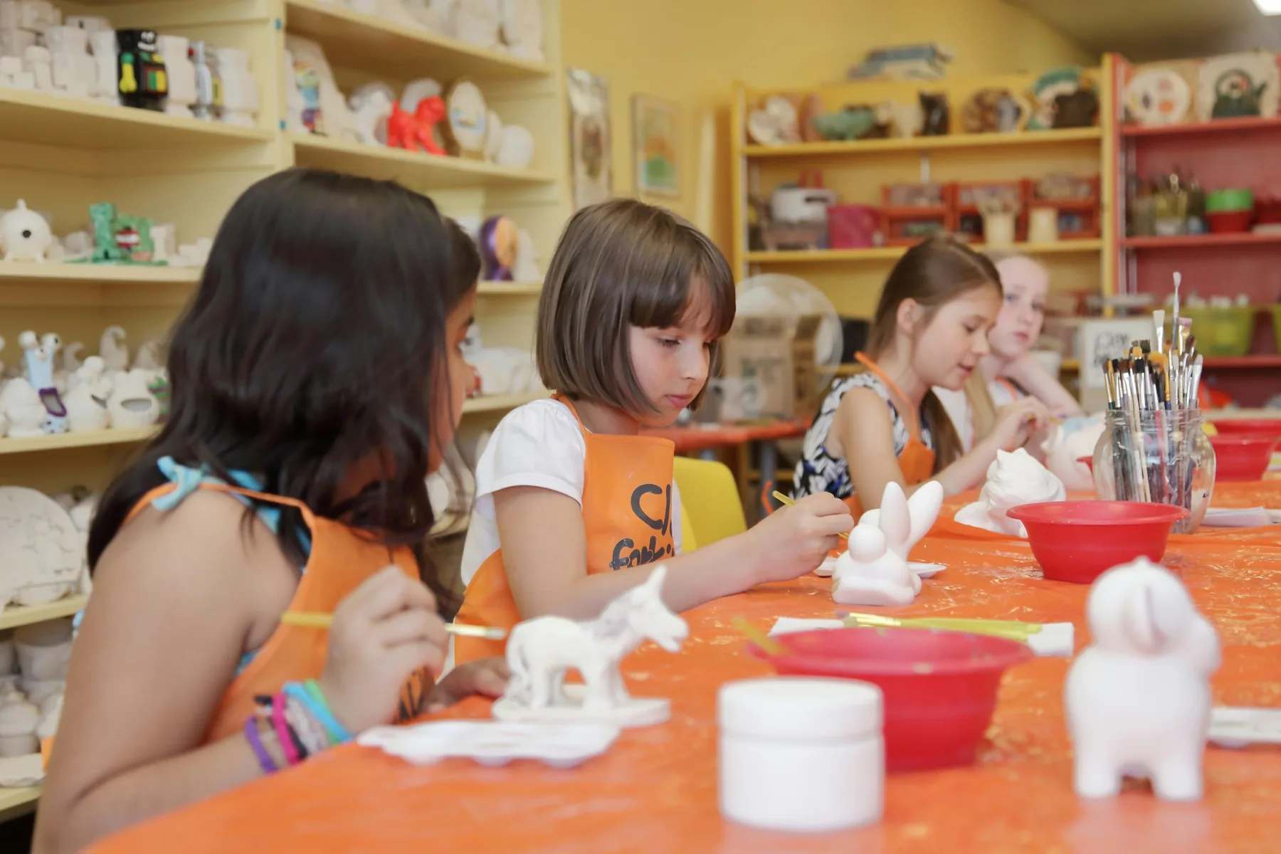 Atelier créatif : des enfants peignent leurs poteries