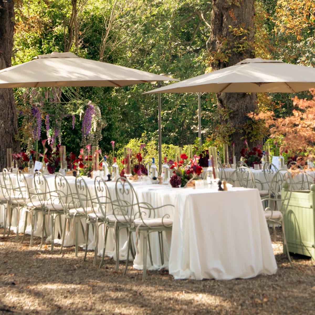 Tables dressées sous les parasols dans le jardin du Pavillon Gravelle